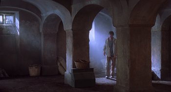 Movie still from “An American Werewolf in Paris” (1997), directed by Anthony Waller – A man standing inside of an arched room; Wide shot, Low angle