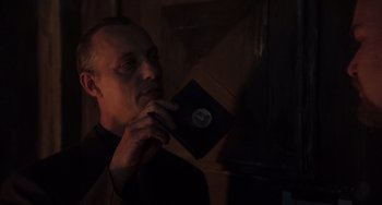 Movie still from “An American Werewolf in Paris” (1997), directed by Anthony Waller – A man holding an old record in his hand; Close Up shot, Over the shoulder angle