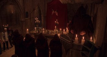 Movie still from “An American Werewolf in Paris” (1997), directed by Anthony Waller – A group of people sitting around a table with candles; Wide shot, High angle