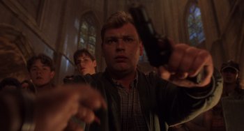 Movie still from “An American Werewolf in Paris” (1997), directed by Anthony Waller – A man holding a gun while standing next to another man; Close Up shot, Low angle