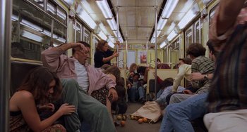 Movie still from “An American Werewolf in Paris” (1997), directed by Anthony Waller – A group of people sitting on top of a subway car; Wide shot, High angle