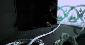Movie still from “An American Werewolf in Paris” (1997), directed by Anthony Waller – A man in a black suit is pulling a white rope; Wide shot, High angle