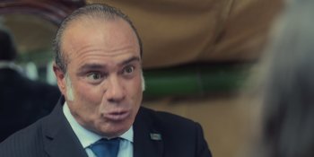 Movie still from “An Unforgettable Year: Summer” (2023), directed by Cris D'Amato – A person wearing a suit and tie; Extreme Close Up shot, Low angle