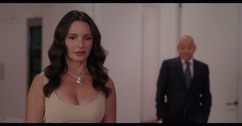 A beautiful woman standing next to an older man