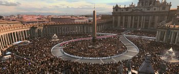 Movie still from “Angels & Demons” (2009), directed by Ron Howard – A crowd of people gathered in a circle in front of an obelisk; Extreme Wide shot, High angle
