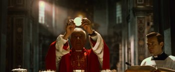 Movie still from “Angels & Demons” (2009), directed by Ron Howard – An older man holding a candle in front of a mirror; Medium shot, Low angle