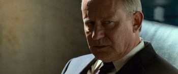 Movie still from “Angels & Demons” (2009), directed by Ron Howard – An older man wearing a suit and tie; Close Up shot, Over the shoulder angle