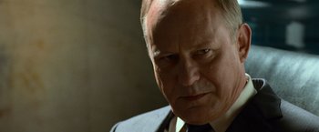 Movie still from “Angels & Demons” (2009), directed by Ron Howard – An older man wearing a suit and tie looking at the camera; Close Up shot, Over the shoulder angle