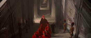 Movie still from “Angels & Demons” (2009), directed by Ron Howard – A group of men in red robes walking down a hallway; Extreme Wide shot, High angle