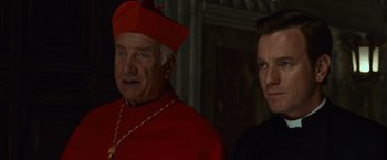 Movie still from “Angels & Demons” (2009), directed by Ron Howard – A man and a woman standing next to each other; Close Up shot, Over the shoulder angle