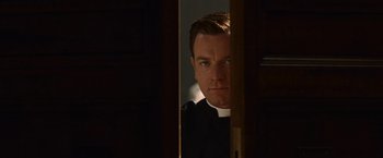 Movie still from “Angels & Demons” (2009), directed by Ron Howard – A man wearing a priest's outfit looking into a mirror; Close Up shot, Low angle