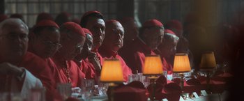 Movie still from “Angels & Demons” (2009), directed by Ron Howard – A group of men in red robes sitting at a table; Medium shot, High angle