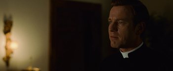 Movie still from “Angels & Demons” (2009), directed by Ron Howard – A person wearing a suit and tie; Close Up shot, Over the shoulder angle