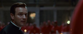 Movie still from “Angels & Demons” (2009), directed by Ron Howard – A person in front of a crowd; Close Up shot, Over the shoulder angle