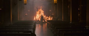 Movie still from “Angels & Demons” (2009), directed by Ron Howard – A man standing in front of a fire in a church; Extreme Wide shot, High angle