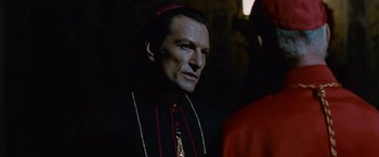 Movie still from “Angels & Demons” (2009), directed by Ron Howard – A person wearing a priest's outfit; Close Up shot, Over the shoulder angle