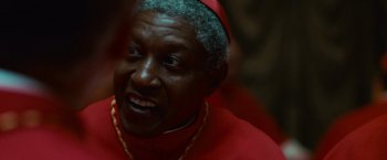 Movie still from “Angels & Demons” (2009), directed by Ron Howard – An older man wearing a red robe and a gold chain; Close Up shot, Over the shoulder angle