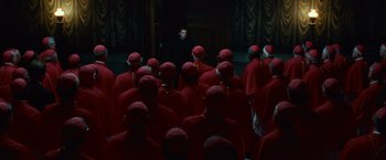 Movie still from “Angels & Demons” (2009), directed by Ron Howard – A group of people in red robes and a man in a black suit; Wide shot, High angle