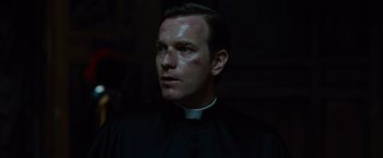 Movie still from “Angels & Demons” (2009), directed by Ron Howard – A man wearing a priest's outfit and a cross on his forehead; Close Up shot, Low angle