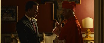 Movie still from “Angels & Demons” (2009), directed by Ron Howard – A man in a suit talking to an older man in a red suit; Medium shot, Over the shoulder angle