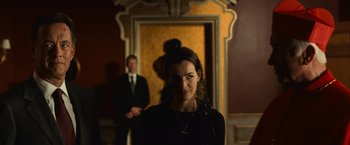 Movie still from “Angels & Demons” (2009), directed by Ron Howard – A woman standing in front of a man in a suit and tie; Medium shot, Over the shoulder angle