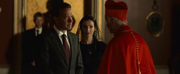 Movie still from “Angels & Demons” (2009), directed by Ron Howard – A man and a woman standing in front of a priest; Medium shot, Over the shoulder angle