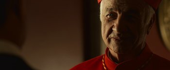 Movie still from “Angels & Demons” (2009), directed by Ron Howard – An older man wearing a red outfit and a red hat; Close Up shot, Low angle