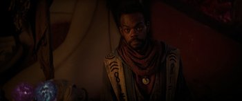 Movie still from “Ant-Man and the Wasp: Quantumania” (2023), directed by Peyton Reed – A man with a beard wearing a scarf and a sweater; Close Up shot, Over the shoulder angle