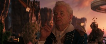 Movie still from “Ant-Man and the Wasp: Quantumania” (2023), directed by Peyton Reed – An old man with a white beard and a blue shirt is holding his hand up to his face; Close Up shot, Over the shoulder angle