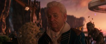 Movie still from “Ant-Man and the Wasp: Quantumania” (2023), directed by Peyton Reed – An old man with a white beard wearing a blue and white jacket; Close Up shot, Over the shoulder angle