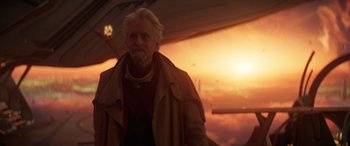 Movie still from “Ant-Man and the Wasp: Quantumania” (2023), directed by Peyton Reed – An older man in a jacket and a red scarf; Medium shot, Over the shoulder angle