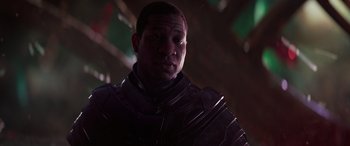 Movie still from “Ant-Man and the Wasp: Quantumania” (2023), directed by Peyton Reed – A man in a black suit is standing in a dark room; Close Up shot, Low angle