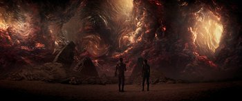 Movie still from “Ant-Man and the Wasp: Quantumania” (2023), directed by Peyton Reed – Two people standing in front of an erupting volcano; Extreme Wide shot, Overhead angle