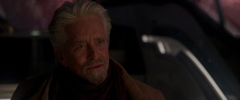 Movie still from “Ant-Man and the Wasp: Quantumania” (2023), directed by Peyton Reed – An older man with white hair wearing a scarf; Close Up shot, Over the shoulder angle