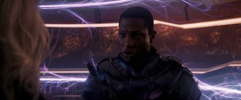 Movie still from “Ant-Man and the Wasp: Quantumania” (2023), directed by Peyton Reed – A man in a purple suit is holding his hand up; Close Up shot, Over the shoulder angle