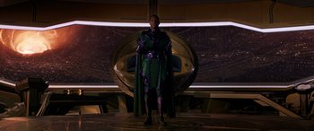 Movie still from “Ant-Man and the Wasp: Quantumania” (2023), directed by Peyton Reed – A man dressed in a green and purple costume stands in front of a wall; Medium shot, Low angle
