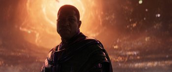 Movie still from “Ant-Man and the Wasp: Quantumania” (2023), directed by Peyton Reed – A man in a black outfit standing in front of an orange background; Close Up shot, Low angle