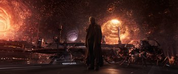 Movie still from “Ant-Man and the Wasp: Quantumania” (2023), directed by Peyton Reed – A man standing in front of an exploding structure; Wide shot, Over the shoulder angle