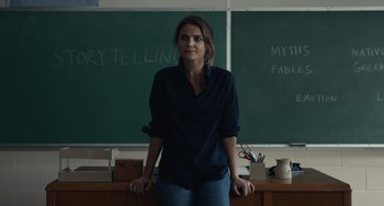 Movie still from “Antlers” (2021), directed by Scott Cooper – A woman standing in front of a chalkboard in a classroom; Medium shot, Over the shoulder angle