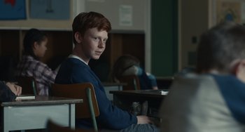 Movie still from “Antlers” (2021), directed by Scott Cooper – A boy sitting at a desk in front of a laptop computer; Close Up shot, Over the shoulder angle
