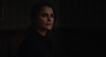 Movie still from “Antlers” (2021), directed by Scott Cooper – A woman in a black shirt is in a dark room; Close Up shot, Over the shoulder angle