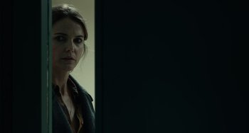 Movie still from “Antlers” (2021), directed by Scott Cooper – A woman standing in front of a wall looking at the camera; Close Up shot, Over the shoulder angle