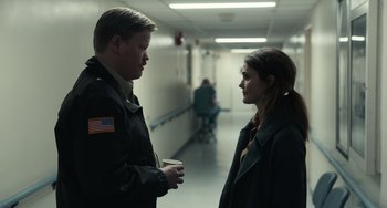Movie still from “Antlers” (2021), directed by Scott Cooper – A man and a woman talking in a hospital hallway; Medium shot, Over the shoulder angle