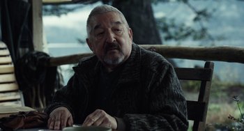Movie still from “Antlers” (2021), directed by Scott Cooper – An older man sitting at a table with his eyes closed; Close Up shot, Over the shoulder angle