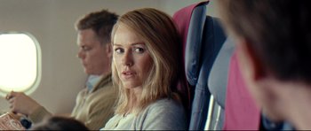Movie still from “The Impossible” (2012), directed by J.A. Bayona – A woman sitting on a seat on an airplane; Close Up shot, Over the shoulder angle