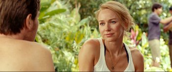 Movie still from “The Impossible” (2012), directed by J.A. Bayona – A woman sitting in front of some trees; Close Up shot, Over the shoulder angle