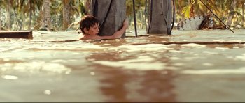 Movie still from “The Impossible” (2012), directed by J.A. Bayona – A young boy is swimming in a body of water; Wide shot, High angle