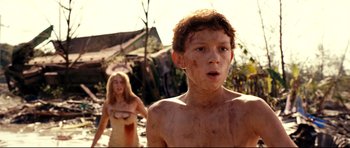 Movie still from “The Impossible” (2012), directed by J.A. Bayona – A young boy and a young woman in a dirt field; Close Up shot, Low angle