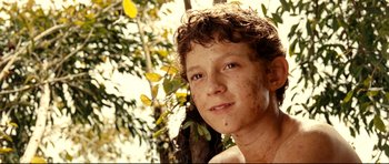 Movie still from “The Impossible” (2012), directed by J.A. Bayona – A young man with a very large smile on his face; Close Up shot, High angle