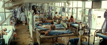 Movie still from “The Impossible” (2012), directed by J.A. Bayona – A group of people in a room with beds; Wide shot, High angle